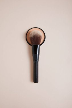 Bej arka planda profesyonel makyaj fırçası olan toz, yakın görüş, güzellik konsepti 