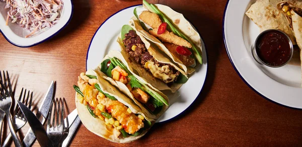 mexican food banner with burritos and quesadilla with salad on wooden background