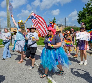 New Orleans, LA, ABD - 14 Haziran 2025: Marigny Mahallesi 'ndeki Krallar Yok Yürüyüşü' ne tabelalı ve baş aşağı ABD bayrağı taşıyan Trump karşıtı protestocular katıldı