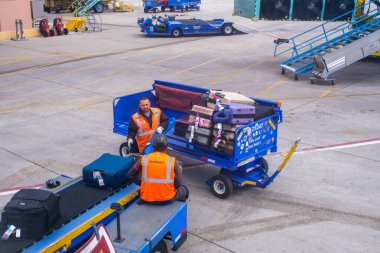 Albuquerque, NM, ABD - 19 Mayıs 2025: Albuquerque Havaalanı 'nda ticari uçaklara turuncu yelek giyen iki işçi