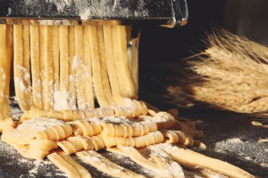 Makarna ve ev yapımı tagliatelle, makine ile un serpilir