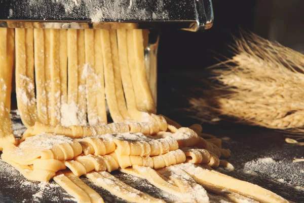 Makarna ve ev yapımı tagliatelle, makine ile un serpilir