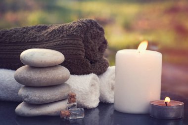 Spa yordamlar için ayarla Bahçe masa, sıcak mum, havlu ve masaj yağı.