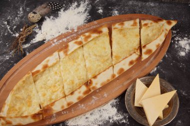 Pide pide denir. Karanlık bir tablo ile un serpilir, peynirli pide ile çanak.