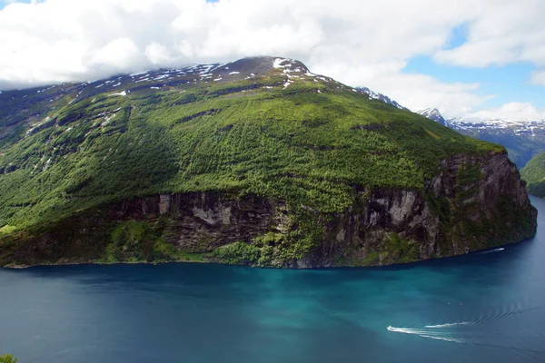 Stunning views of the Norwegian fjord with blue water and emerald greenery