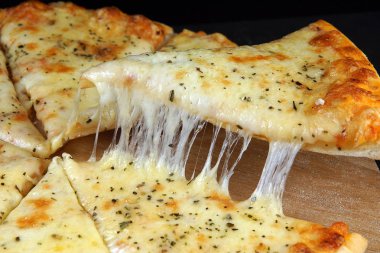 Sıcak iştah açıcı peynirli pizza, parçalar halinde kesilmiş ve bunlardan biri aldı.
