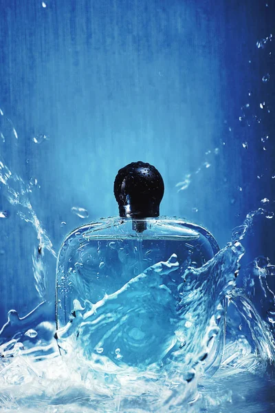 Bouteille Avec Parfum Sur Fond Bleu Avec Eau Des Pulvérisations — Photo