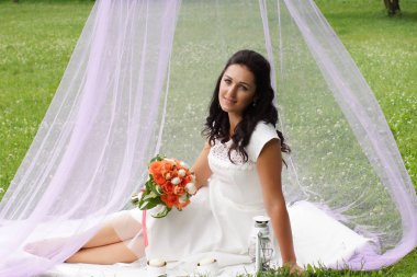 Nazik bir buket pembe bir çadırda parkta gelinle.