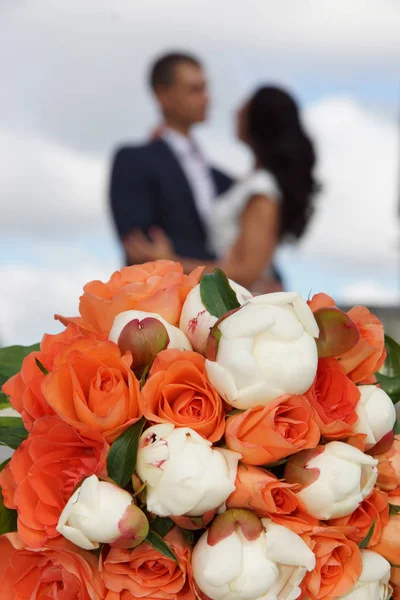 Yeni Evli Bir Kucaklama Bir Düğün Buket Arka Planda Uzakta — Stok fotoğraf