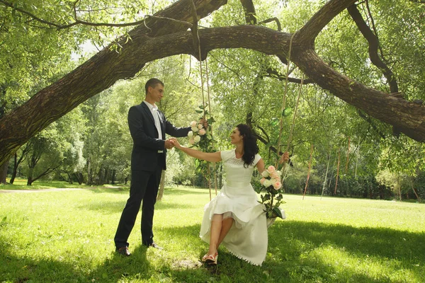 Beautiful Swings Suspended Park Tree Bride Sits Swing Holds Bridegroom — Stock Photo, Image