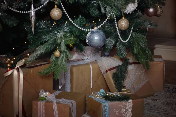 Beaucoup de beaux cadeaux, dans un style rustique, se trouvent sous un arbre de Noël — Photo