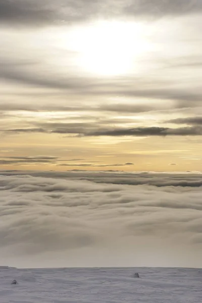 Paisaje invernal con nubes por debajo y comenzando con el atardecer — Foto de Stock