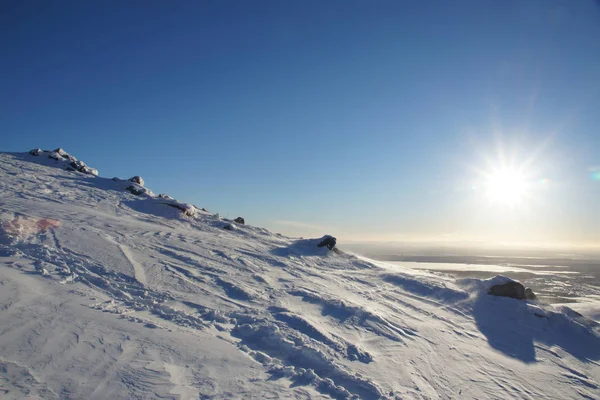 Paisaje en las montañas en invierno con nieve blanca y el sol en un cielo azul — Foto de Stock