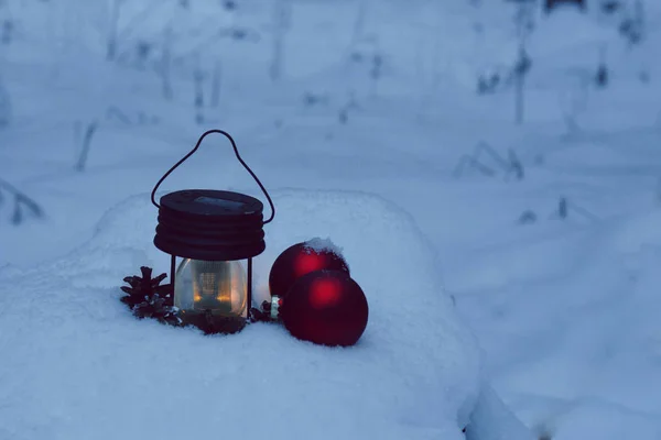 Hořící baterku a vánoční dekorace v závěji s twilight Les — Stock fotografie