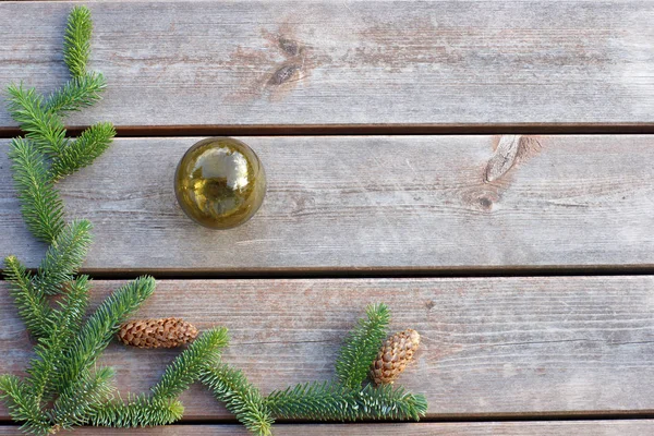 Zelené smrkové větve leží na dřevěné pozadí s skleněná mísa — Stock fotografie