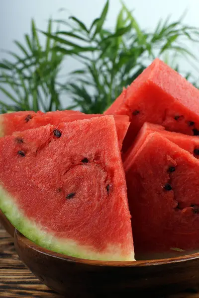 Rote Wassermelone Dreieckige Stücke Geschnitten Einer Holzschale Mit Grünen Palmblättern — Stockfoto