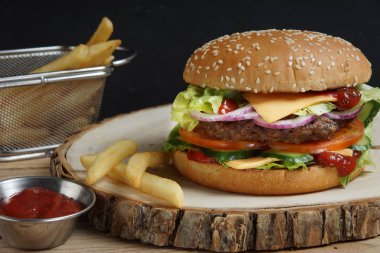 Kokulu büyük hamburger köfte, domates, salatalık, peynir, soğan ve salata ile. Kırmızı sos ve patates kızartması.