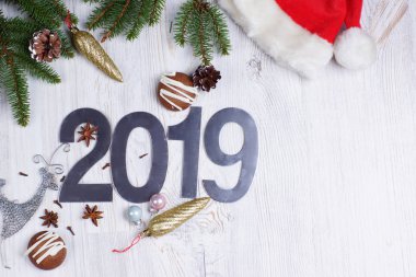 Rakamlar 2019, kurabiye ve Noel süslemeleri ile hafif bir arka plan üzerinde kırmızı bere bir Noel ağacı. metin için yer kopyalayın. Yeni yıl kavramı. Tebrik Noel kartı. Düz yatıyordu.
