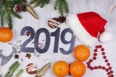 Numaraları 2019, Santa şapka, çam dalları ve hafif bir arka plan üzerine mandalina ile Noel düzeni. Yeni yıl kavramı. Tebrik Noel kartı. Düz yatıyordu.