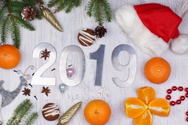 Noel düzen numaralarını 2019, Santa şapka, süs eşyaları, Noel ağaç dalları ve mandalina hafif ahşap arka plan üzerinde. Yeni yıl kavramı. Tebrik Noel kartı. Düz yatıyordu.