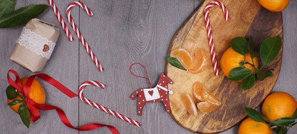 크리스마스 캔디 지팡이, 귤, 나무 말과 소박한 스타일 선물의 개념 — 스톡 사진
