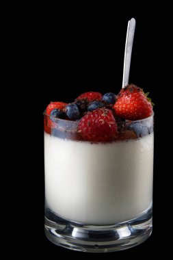 Panakota krem İtalyan tatlı çilek ve bir kaşık ile cam Kupası.