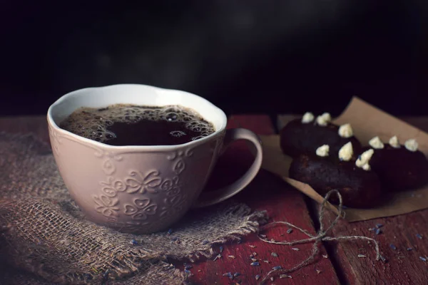 Café de la mañana en una taza marrón en la mesa junto a pasteles en forma de patata — Foto de Stock