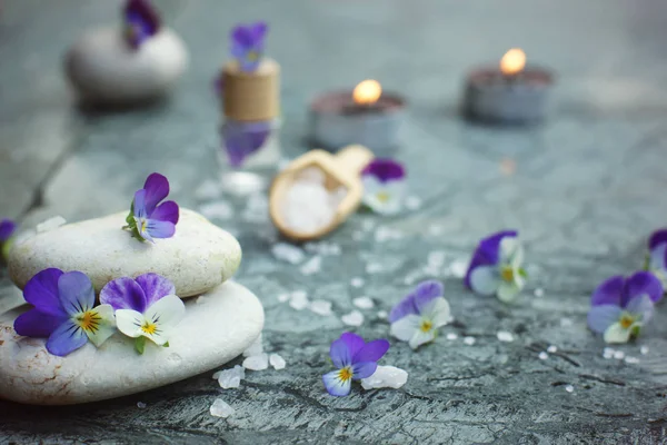 Spa concept met brandende kaarsen, Massage stenen en zeebad zout, decoratie van paarse bloemen — Stockfoto