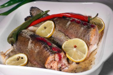 Kırmızı alabalık beyaz ısıya dayanıklı çanak limon ve acı biber ile fırında pişmiş