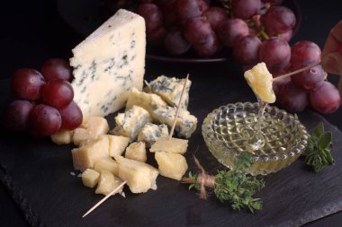 Bir dilim peynir, meze olarak üzümle yemeden önce bala batırılır.