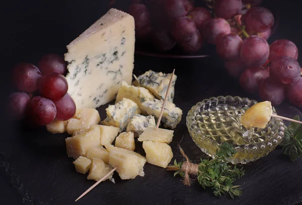 Üzümle yemeden önce balpeyniri bir dilim. Baharatlı otlar yakınında.