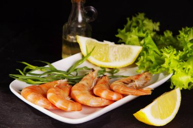 Karidesler pişirmeden önce diğer malzemelerin yanında yer.