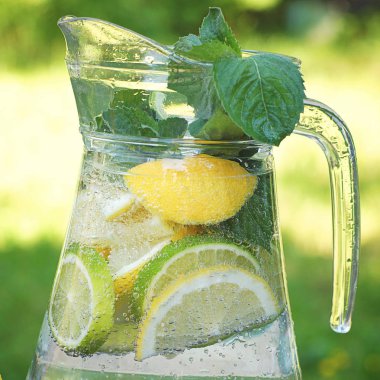 Bir dekantör doğal limon, limon ve nane ile gazlı içecek