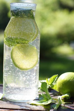 Nane ve kireç ile şeffaf bir şişe de ev yapımı mojito kokteyl güzel kabarcıklar