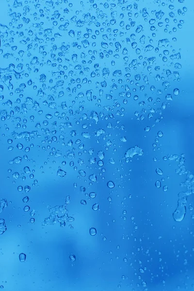 Blue background with droplets on a transparent surface