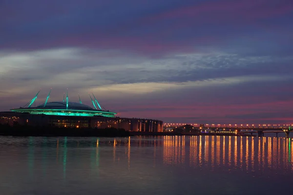Beautiful backlit stadium is reflected in the bay at sunset
