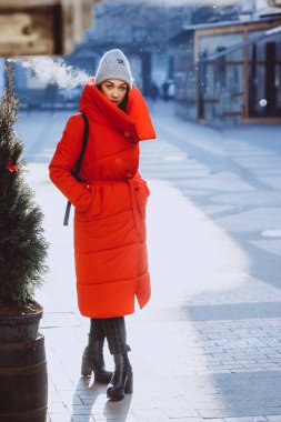 yaşam tarzı moda portre genç ve güzel kadın kırmızı ceket ve gri şapka konaklama yılbaşı ağacı Yılbaşı sokakta yakınındaki ördü. Noel, yeni yıl kavramı.