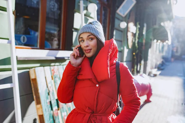 Красивая Женщина Разговаривает Мобильному Телефону Красном Пальто Серой Шляпе Улице — стоковое фото