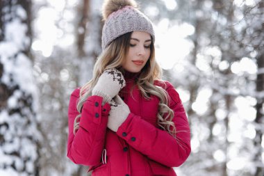 Bir gri çok güzel parlak bir genç kız kar kış park arka plan şapka ve kırmızı mittens ördü. Kış tatil kavramı. -Görüntü