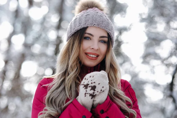 户外近距离画像的年轻美丽女孩温暖的手和微笑 女孩穿着温暖的冬衣 帽子在冬天的森林里摆姿势 圣诞节 寒假的概念 图片仅供参考 — 图库照片