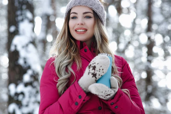 亲密的年轻女孩拿着蓝色的热杯与咖啡或热茶针织手套和微笑在冬季公园的肖像 寒假概念 — 图库照片