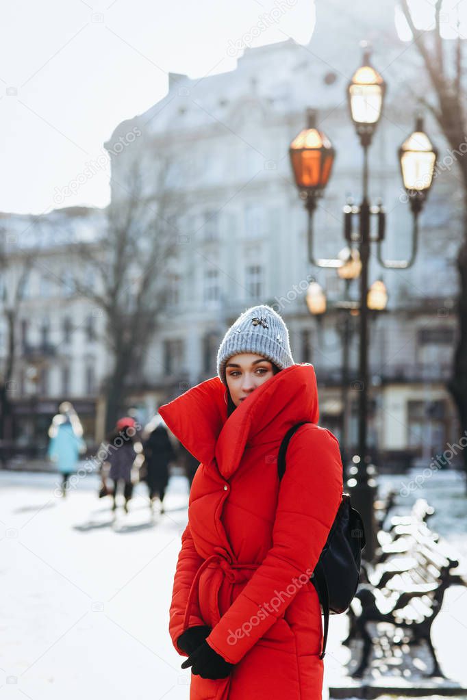 Woman look out of the collar in the old city. Old bench and lanterns on the baground. Christmas, new year and winter holiday concept