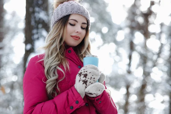 ゴージャスな若い女の子の肖像画を青熱カップ コーヒーやニットの手袋で熱いお茶を保持 周辺とウィンターパークの笑顔します スノース マイル 冬の休日コンセプト イメージ — ストック写真