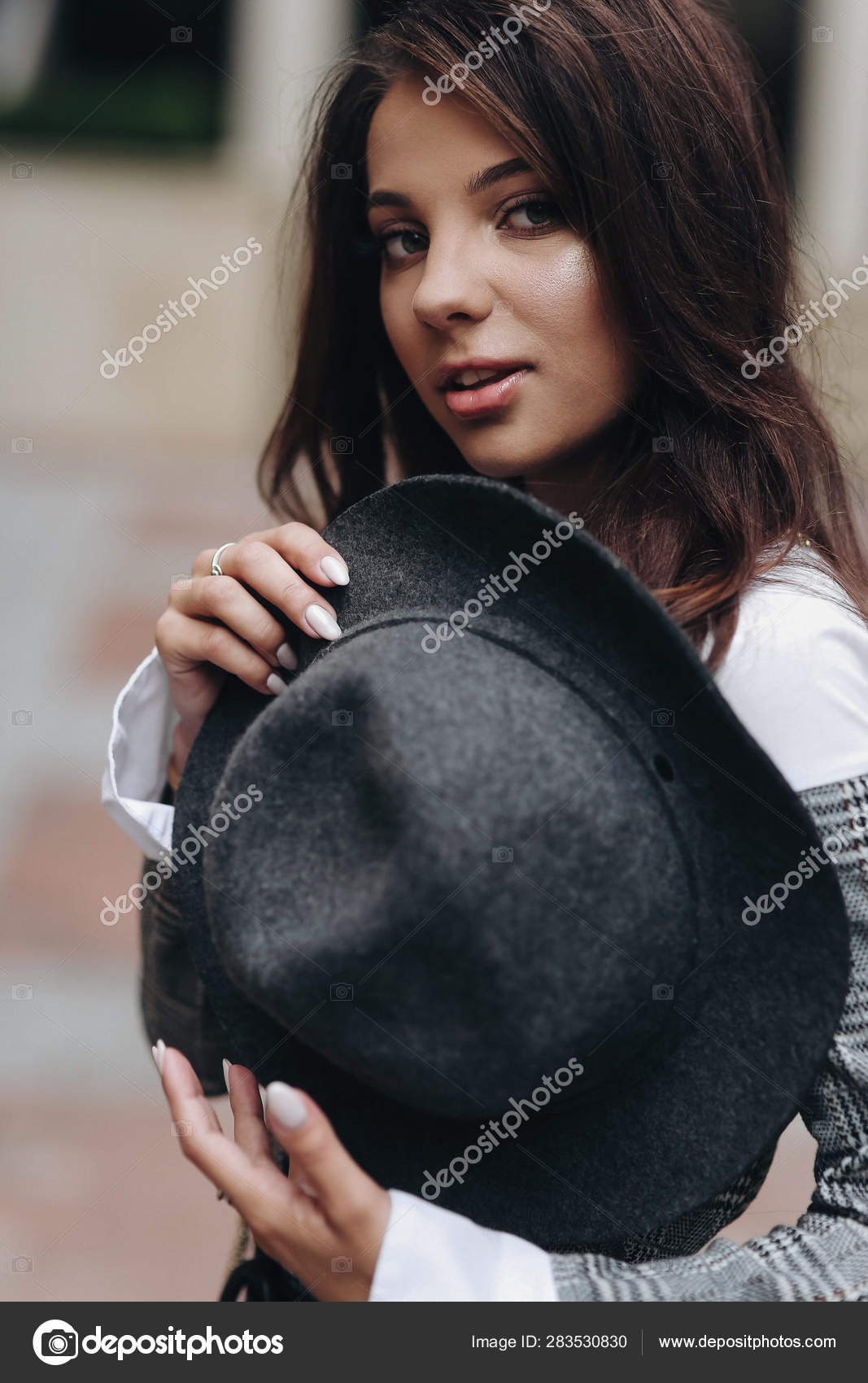 Beautiful Dark Haired Girl In Gray Jacet Hold A Hat On Her Chest