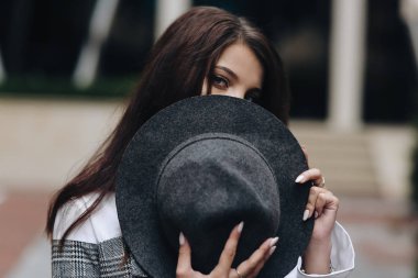 Güzel gözleri ve sokak backgroun üzerinde koyu saçlı utangaç kız