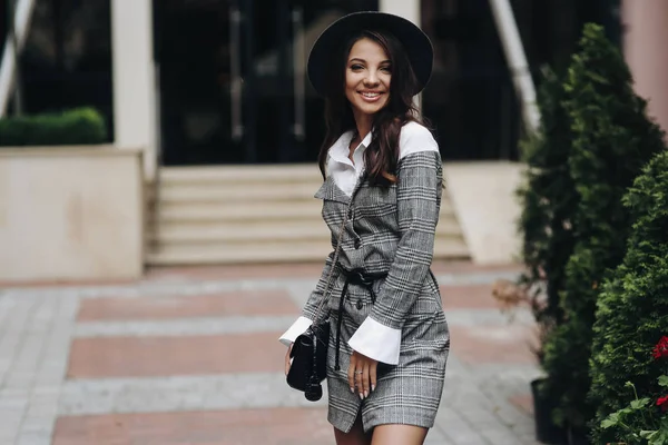 Улыбающаяся девушка в стильной шляпе, пиджаке и высокой куртке — стоковое фото