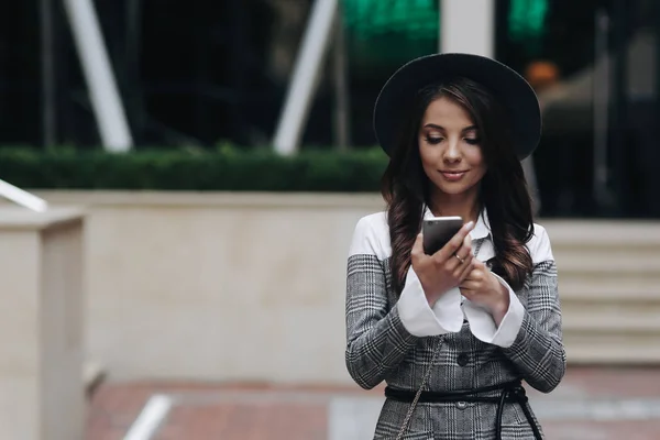 Счастливая женщина, использующая смартфон на улице. Портрет молодого b — стоковое фото