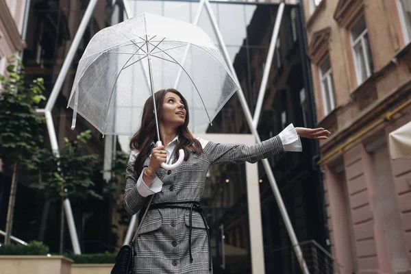 Retrato de una mujer feliz bajo un paraguas cerca de la oficina, wai —  Fotos de Stock