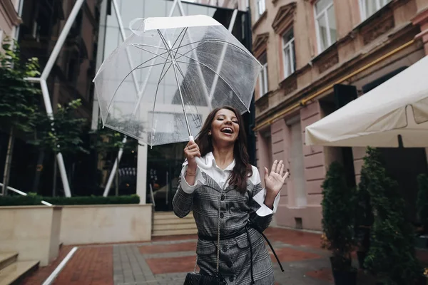 Retrato de una mujer feliz riendo con paraguas cerca del café . — Foto de Stock