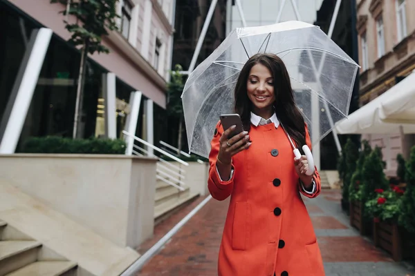 Hermosa mujer morena sonriente con paraguas día lluvioso en rojo —  Fotos de Stock